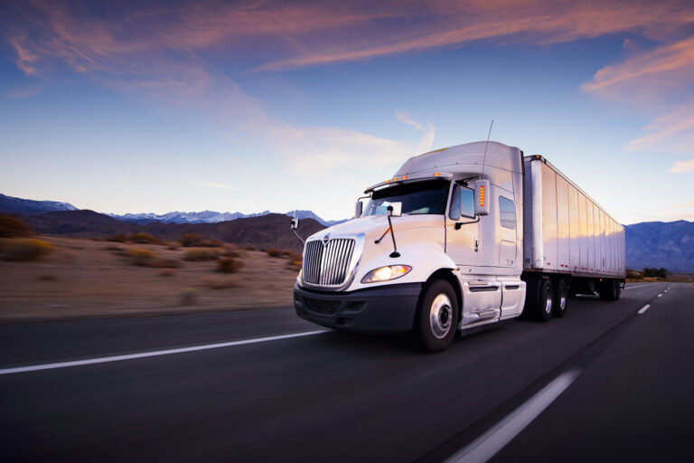 A white semi-truck driving on the road.