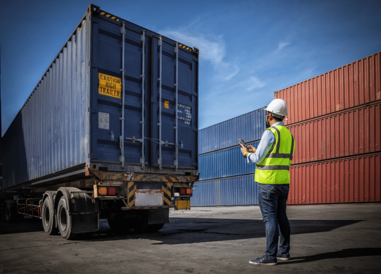 An employee directing a transportation truck in a warehouse